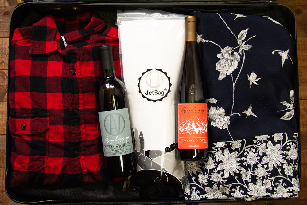 
                  
                    Load image into Gallery viewer, A JetBag, used to protect your wine while traveling, sits in an opened and fully packed suitcase with a bottle of Aubrey Vineyards Frontenac Rose and Aubrey Vineyards Chambourcin Semi-Dry.
                  
                