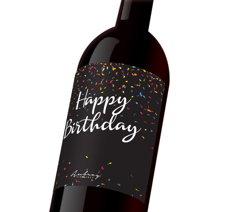 A black custom wine label with colorful confetti that reads, "Happy Birthday".