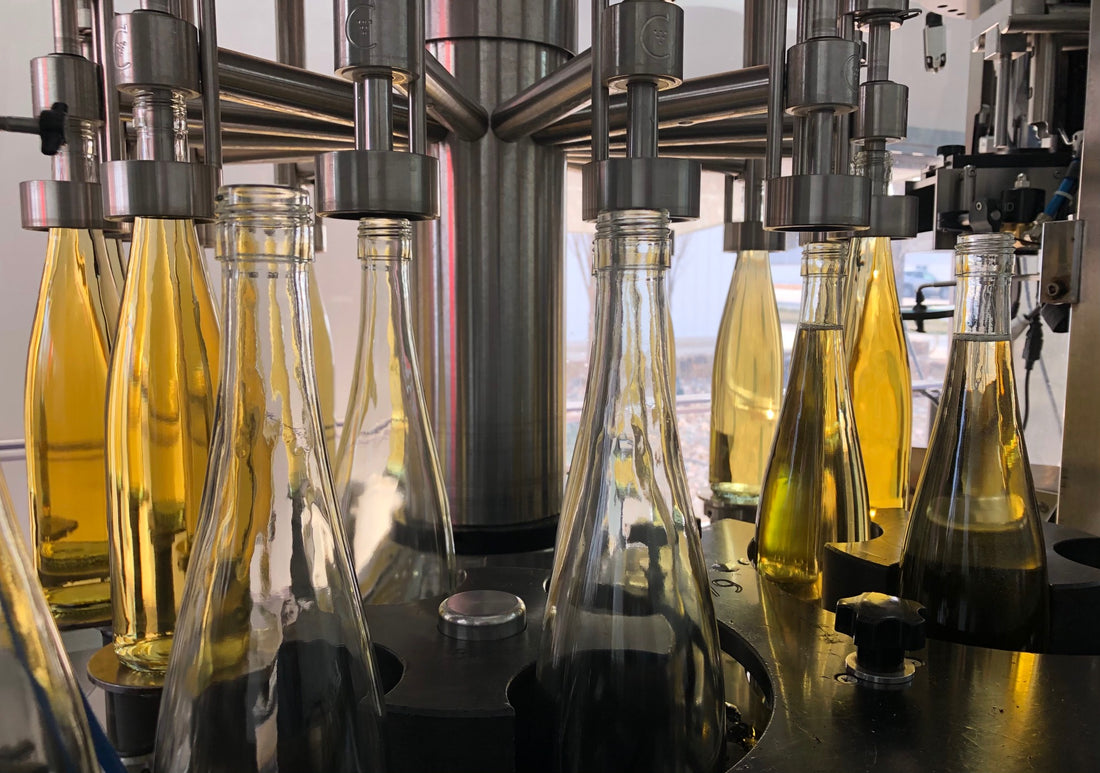 Bottles being filled with white wine during bottling day at Aubrey Vineyards.