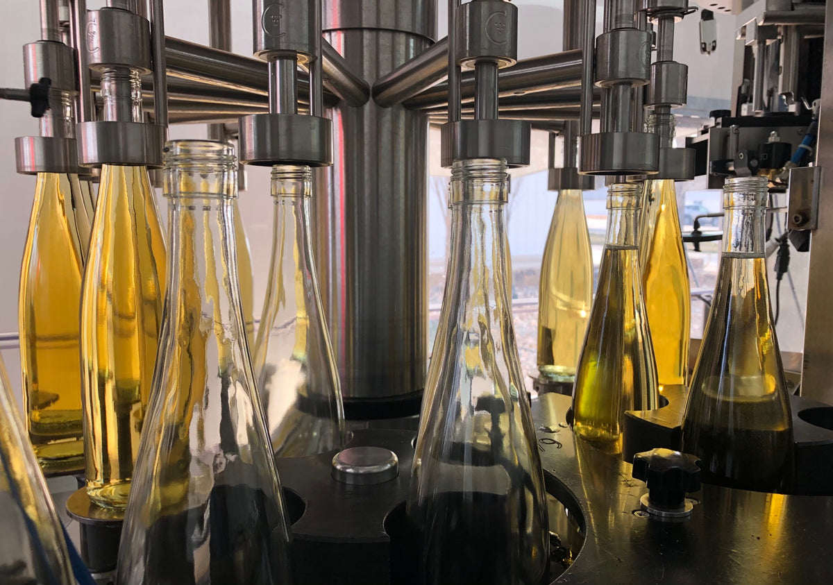 Bottles being filled with white wine during bottling day at Aubrey Vineyards.