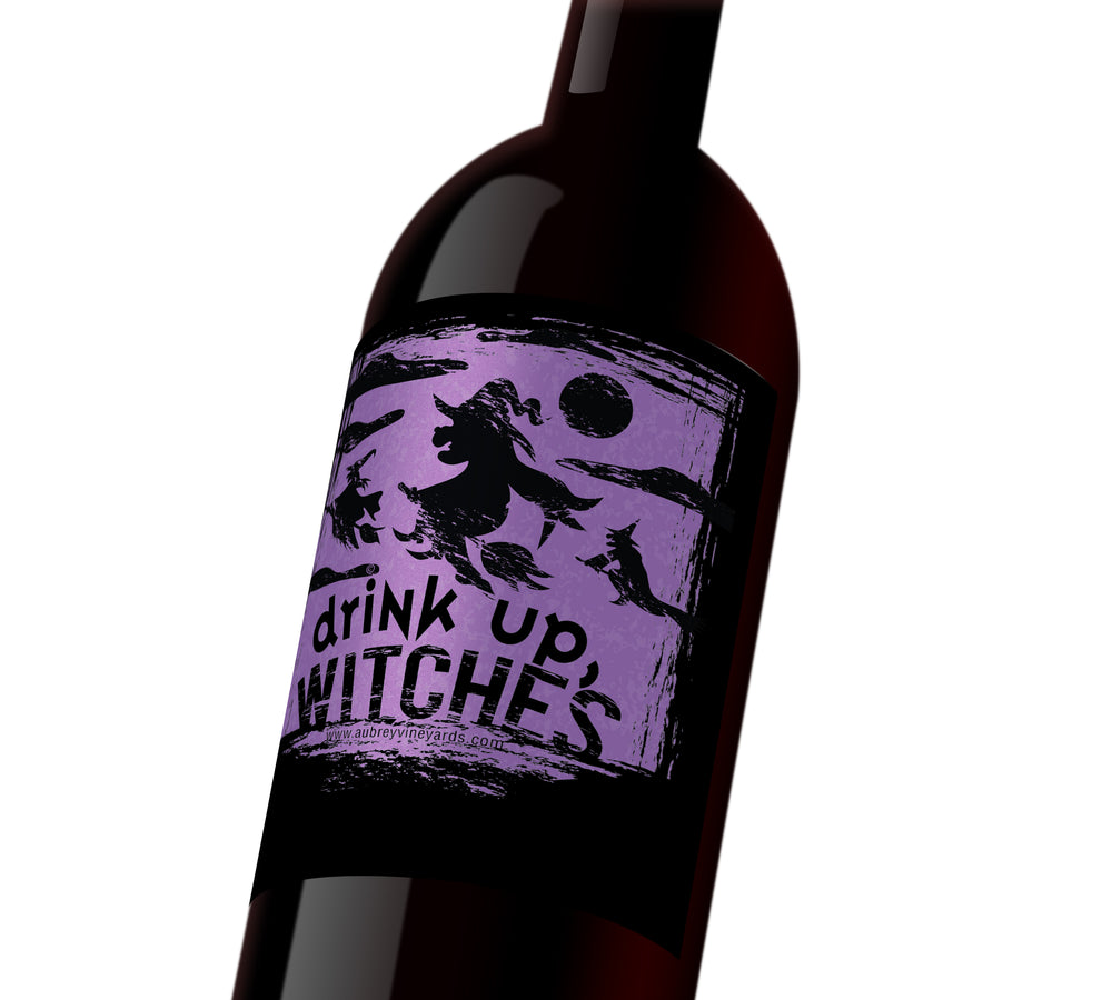 A black and purple Halloween wine label depicting witches on their brooms in the night sky. The label reads, 
