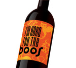An orange Halloween wine label with cats, ghosts, and spiderwebs that reads, "I'm here for the boos".